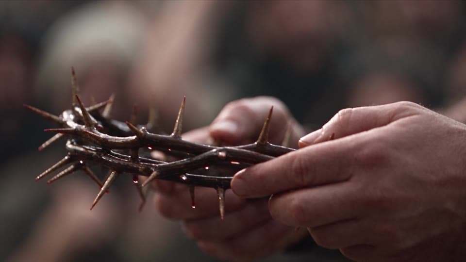 Extreme close-up of the crown of thorns in a soldier’s hands