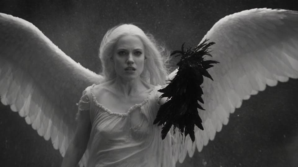 Shot 12: She hangs in the storm holding the torn wing.
